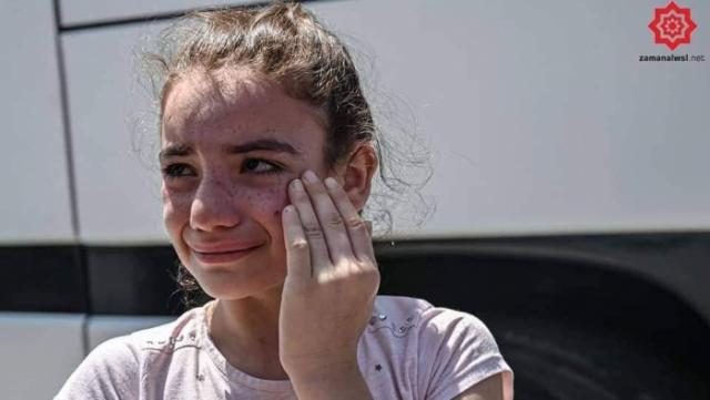 طفلة وهي تغالب الدموع قبل الصعود إلى حافلة الترحيل